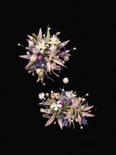 The CAMELLIA Korean Purple Wedding Flower Rings showcase two clusters of assorted preserved flowers and leaves, featuring pink, white, and purple blooms elegantly arranged against a black background.